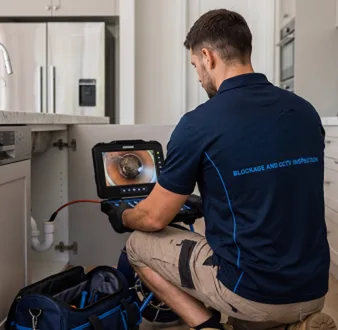 Plumber clearing a blocked toilet in a Millers Point bathroom